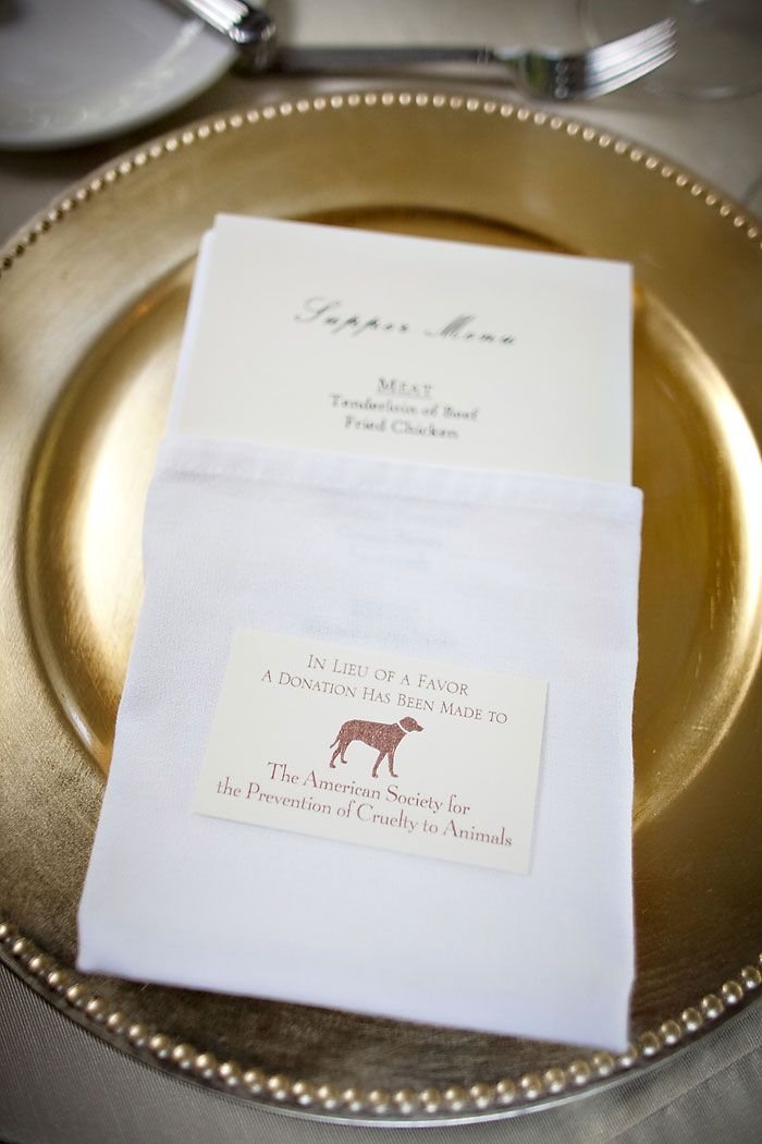 Charity donation wedding favor card on gold charger plate in lieu of a favor