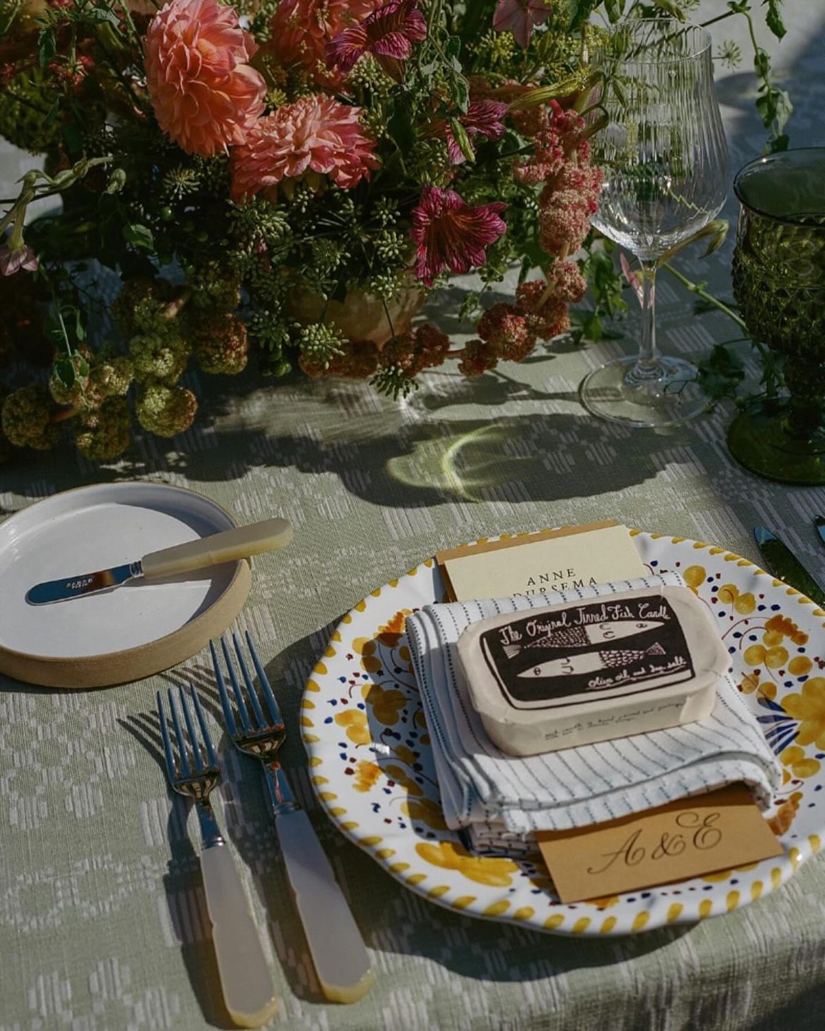 Tinned fish candle wedding favor on colourful ceramic plate at destination wedding table setting