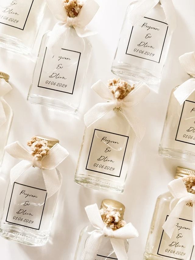Personalised essential oil bottle wedding favors with dried flowers and ribbon