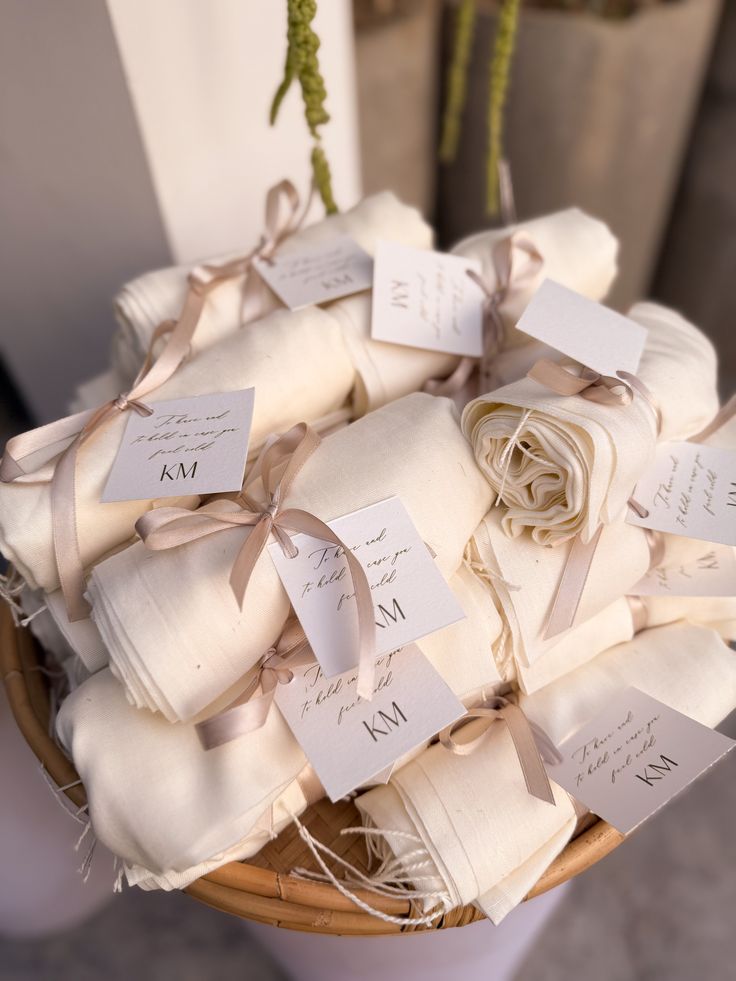 Basket of cream shawl wedding favors with ribbon and monogram tags