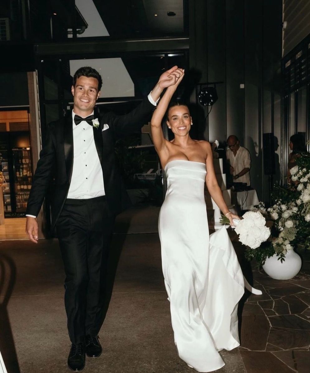 Newlyweds celebrating with hands raised after mr and mrs quiz