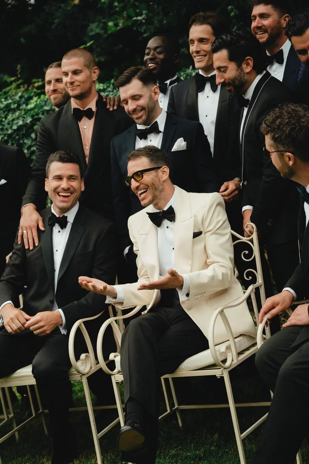 Groom laughing with groomsmen at wedding during mr and mrs quiz about him