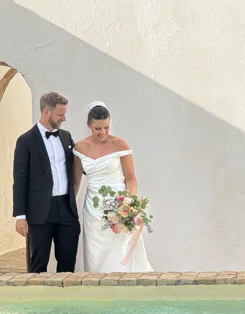 Bride and groom smiling with bouquet